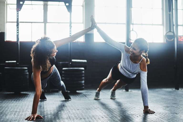 gym two women high five working out