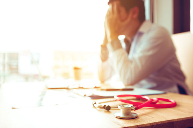 vet male tressed at desk stethoscope