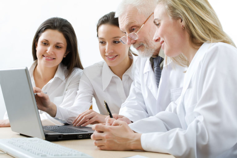 Veterinarian and staff looking at laptop