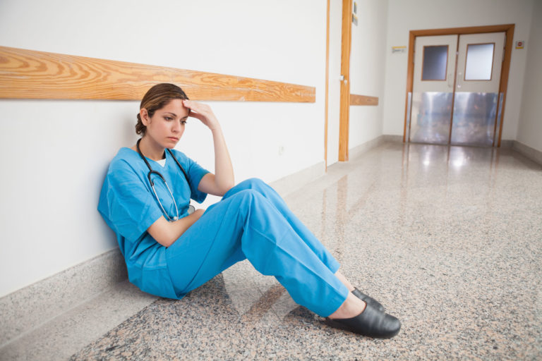 woman vet sitting in hay unhappy