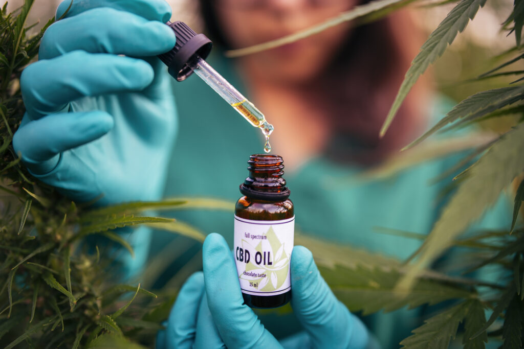 A woman holding a bottle of CBD (cannabidiol) oil.