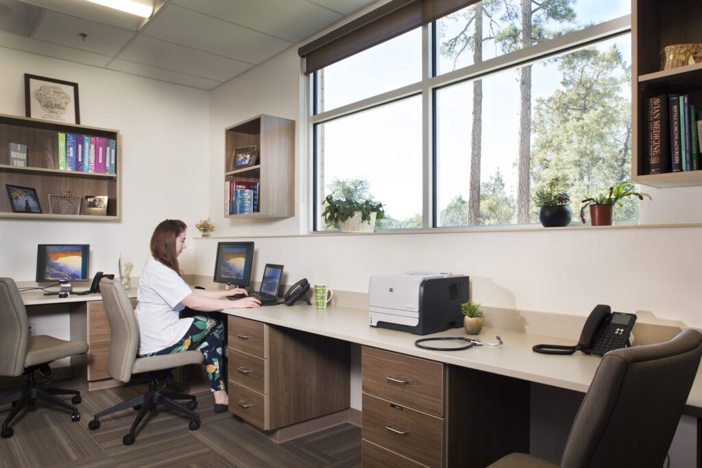 An office with high windows letting in natural light. 