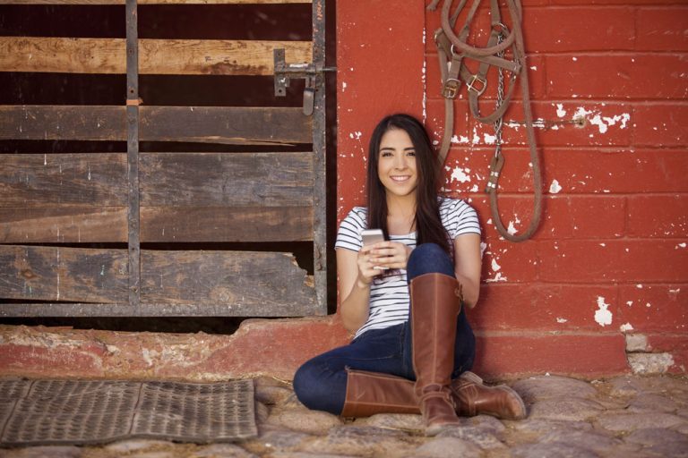 young woman on phone at barn
