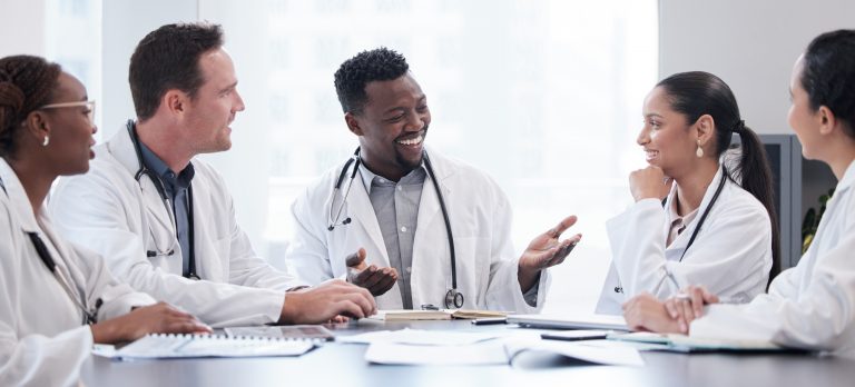 Cropped shot of a group of young doctors having a meeting around a table in the hospital boardroom