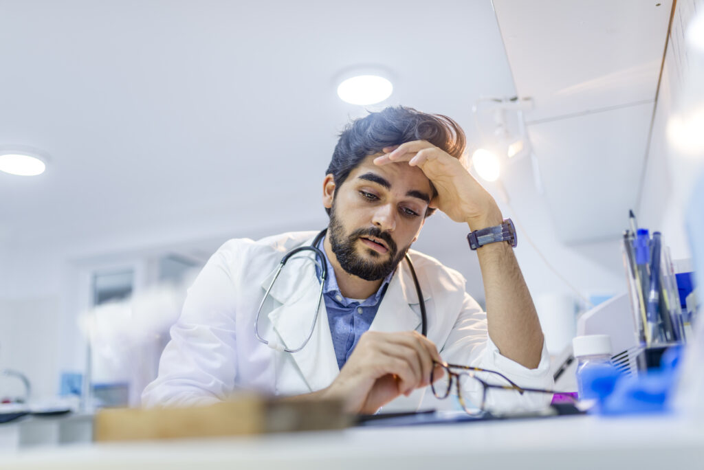 Tired, stressed doctor experiencing compassion fatigue. 
