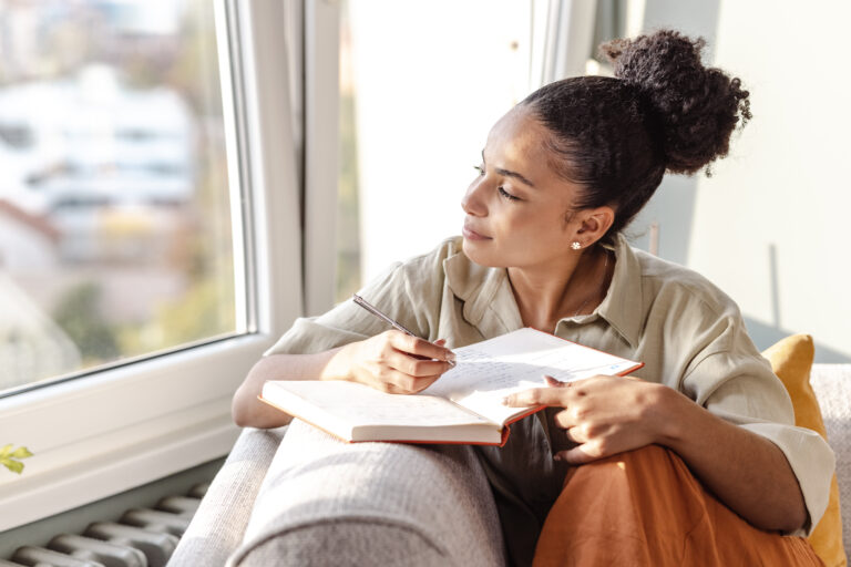 Young African American woman writing notes