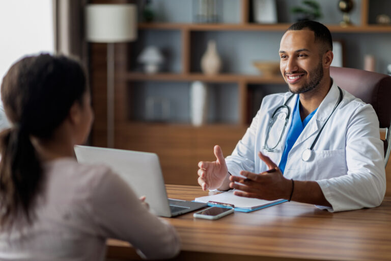 Positive arab doctor consulting african american lady patient