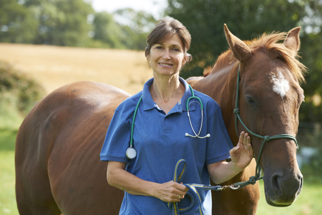 Equine veterinarian posing with horse.