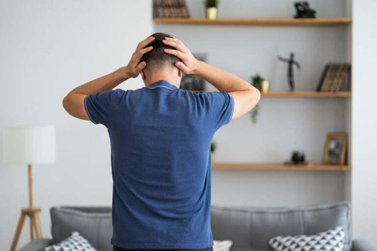 Headache and migraine, man with head pain in home interior