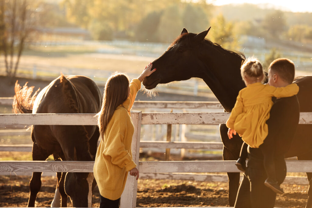 Equine veterinarian parents visiting horses, balancing parenthood and equine practice. 