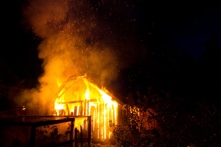 Wooden house or barn burning on fire at night