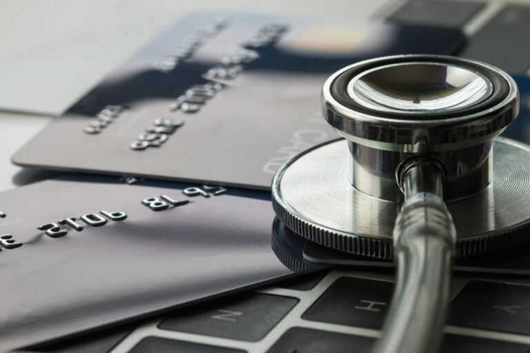 Stethoscope on Mock up Credit Card with number on card at computer in hostpital desk