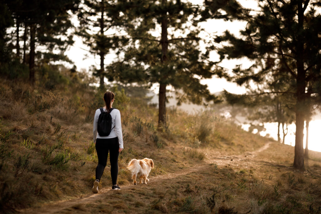 Woman hiking with dog as a strategy for managing anxiety. 
