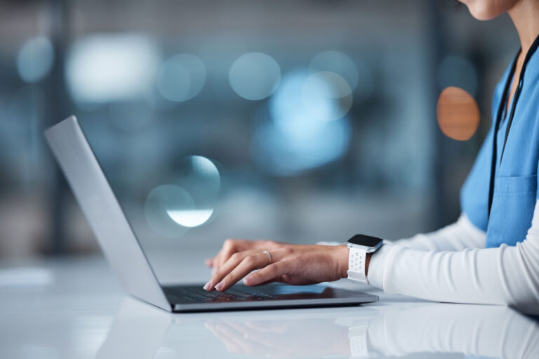 Doctor, hands and laptop in healthcare research, browsing or searching online for medical data at night in a hospital