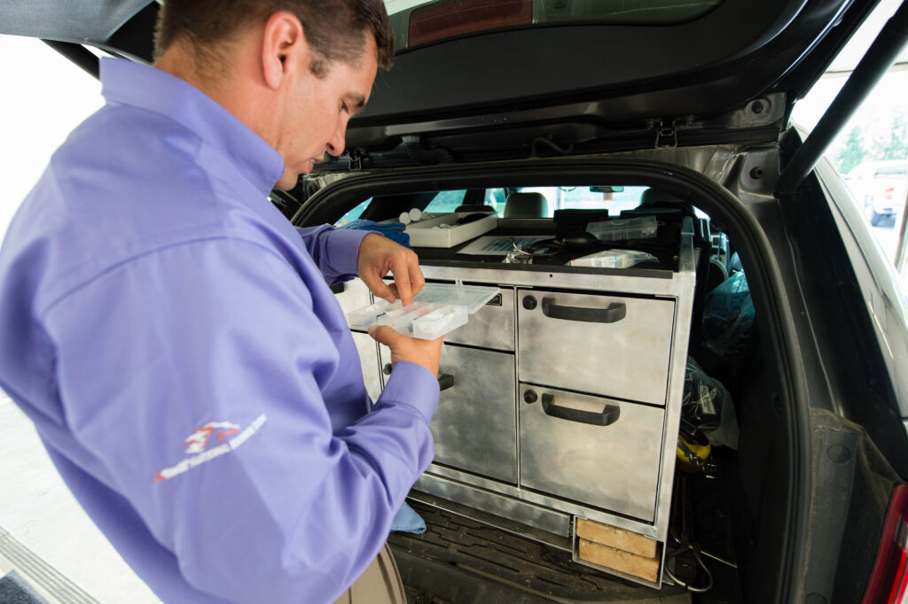 Veterinarian getting supplies out of an SUV hatchback.