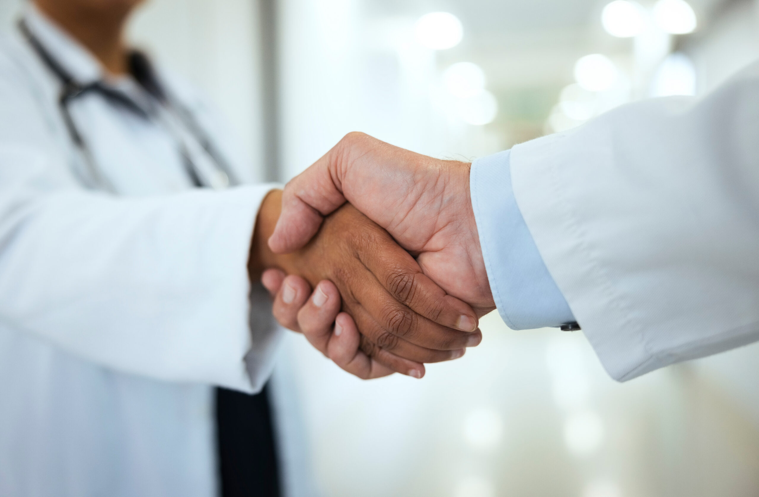 Doctors, handshake and partnership, agreement and support in team at hospital for healthcare